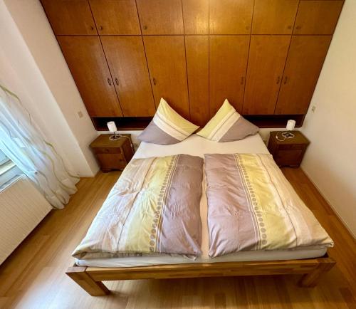 a bed with a wooden headboard and pillows on it at Ferienwohnung Fuldawiesen in Schlitz