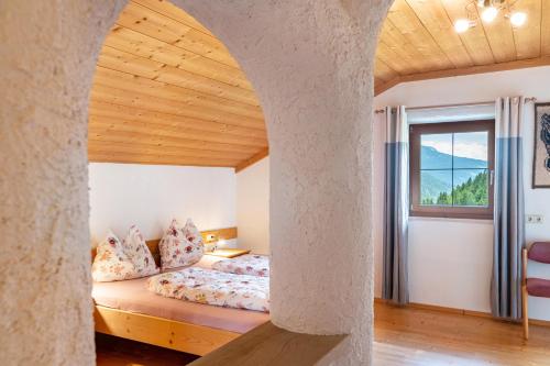 a bedroom with a bed and a large window at Eggerhof im Sarntal in Sarntal