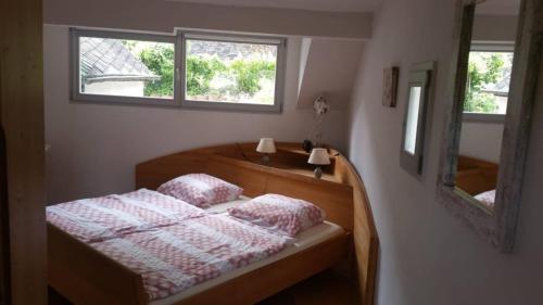 a bedroom with a bed with two pillows and a mirror at Haus Moselschleife in Bremm
