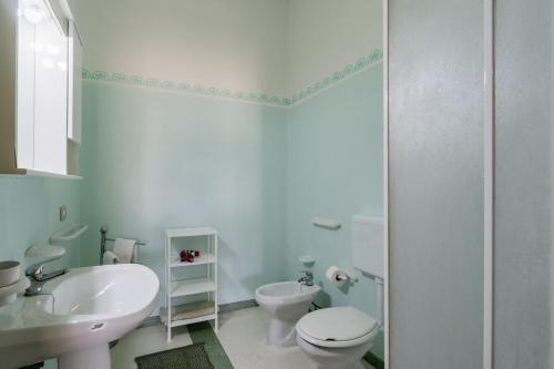 a white bathroom with a toilet and a sink at Domus mea salento Arazzo Verde in Ugento