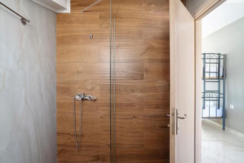 a wooden door in a bathroom with a shower at Iguana studio 17 in Preveza