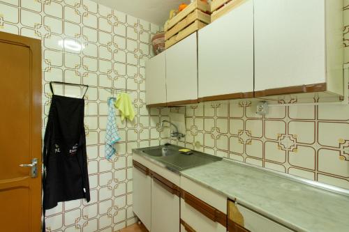 a kitchen with a sink and white tiled walls at Villa Alejo in Valsequillo