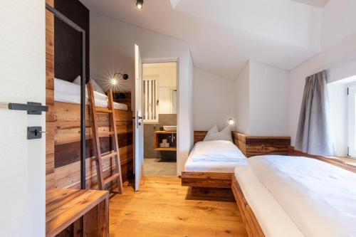 two beds in a room with wooden floors at Innerbachlerhof - Gantkofel in Postal