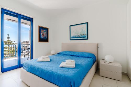 a bedroom with a blue bed and a balcony at Dimora di Artemide in Otranto