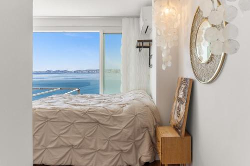 a bedroom with a bed and a large window at Dúplex Paradise above the sea in Benalmádena