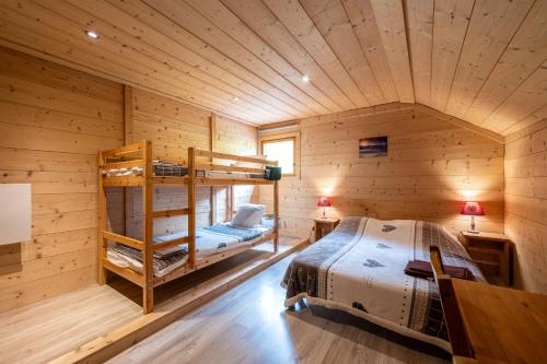a bedroom with bunk beds in a wooden cabin at Les Chalets de la Revue in Flumet