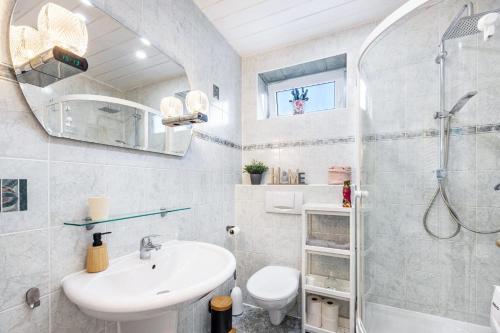 a bathroom with a sink and a shower and a toilet at Ferienwohnung Deister Blick in Rodenberg