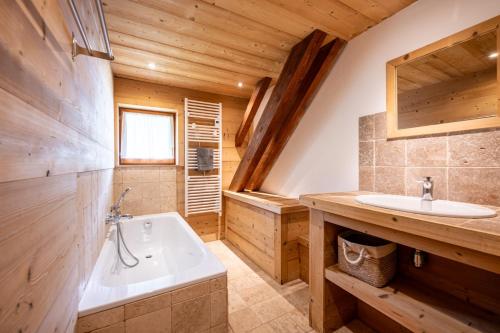 a bathroom with a tub and a sink at Les Chalets de la Revue in Flumet