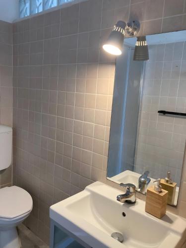 a bathroom with a sink with a mirror and a toilet at Fattorialmare Rossa in Camogli
