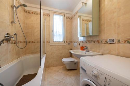 a bathroom with a tub and a toilet and a sink at Appartamento Rocchetta in Salò