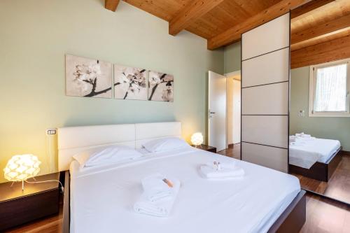 a bedroom with two beds and a mirror at Appartamento Rocchetta in Salò