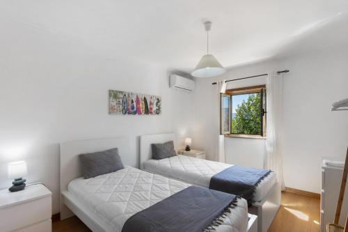 a bedroom with two beds and a window at Casa do Valado in Resende