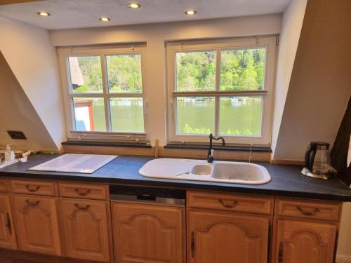 a kitchen with a sink and two windows at Traum-Fewo Mosel-Panoramablick in Traben-Trarbach