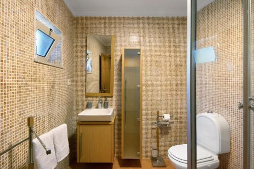 a bathroom with a toilet and a sink at Casa do Valado in Resende