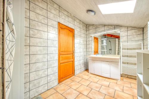 a bathroom with a wooden door and a mirror at L'Ecurie in Guizengeard