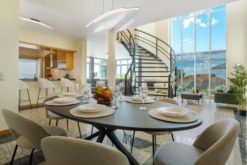 a dining room with a table and chairs and a staircase at Pico Do Paraíso in Funchal