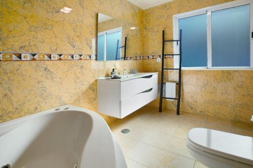 a bathroom with a tub and a sink and a mirror at Pico Do Paraíso in Funchal
