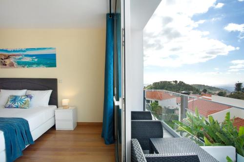 a bedroom with a bed and a balcony at Pico Do Paraíso in Funchal