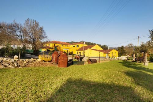 a yard with a yellow house in the background at Df Alojamentos e Suites in Coimbra