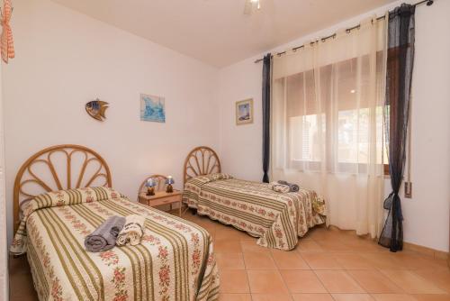 a bedroom with two beds and a window at Casa Mabelle in Palau