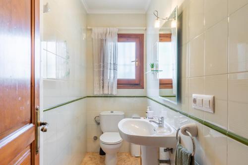 a bathroom with a toilet and a sink and a mirror at La Boniquesa in Benissa