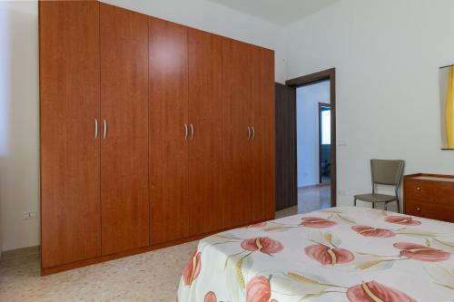 a bedroom with a bed and wooden cabinets at Rosa dei Venti Grottaglie in Grottaglie