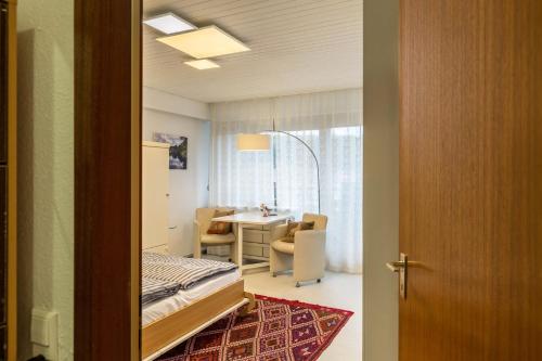 a room with a bed and a desk and a table at Ferienwohnung Nina in Schönwald