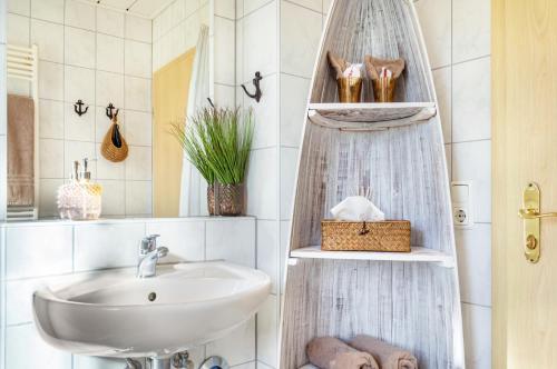 a bathroom with a sink and a shower curtain at Seeblicksuiten - Suite Seelixir in Enderndorf