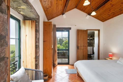 a bedroom with a bed and a large window at Quinta das Queimadas in Nordeste