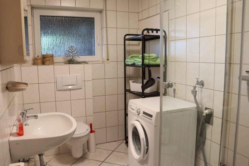 a bathroom with a washing machine and a sink at Ferienwohnung Voege am Waldrand in Schmallenberg