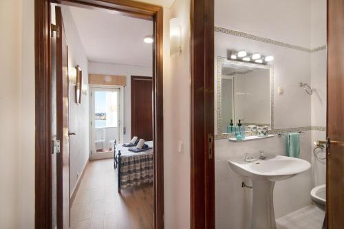 a bathroom with a sink and a mirror at Apartamento Caravela in Armação de Pêra