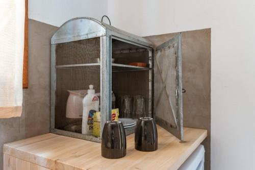 a kitchen counter with an old glass cabinet at En Tino 1 in Tinos