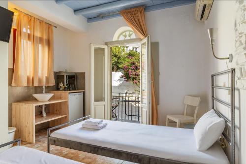 a bedroom with a bed and a kitchen at En Tino 1 in Tinos