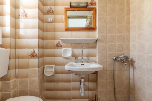 a bathroom with a sink and a toilet and a mirror at Perasma Studio 3 in Kipri
