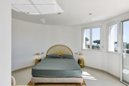 a bedroom with a bed and two windows at Villa de Luxe à Begur Vue Mer in Begur