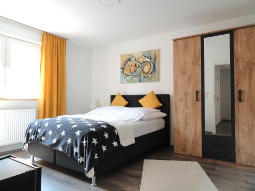a bedroom with a black and white bed and a mirror at Karins Pension in Lampertheim