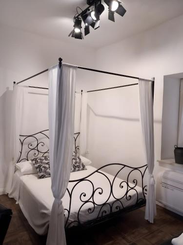 a bedroom with a canopy bed with white curtains at Appartamento Luxury - Torre in Terracina