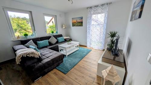 a living room with a couch and two windows at Ferienwohnung Strandliebe in Lubmin