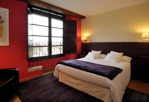a bedroom with a large bed with red walls and a window at luxury stone villa in Girona