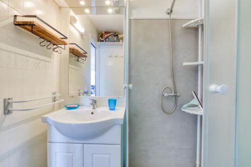 a white bathroom with a sink and a shower at Les Ptits Loups, le Grau d'Agde in Le Grau-dʼAgde