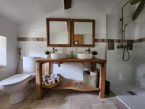 a bathroom with two sinks and a toilet at Le Gite du Bois Renard in Lorigné