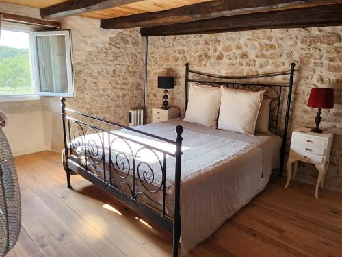 a bedroom with a bed with a metal bed frame at Le Gite du Bois Renard in Lorigné
