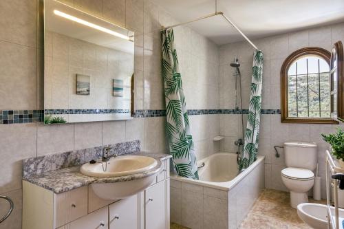 a bathroom with a sink and a tub and a toilet at Castell Mirto - villa private pool in Calonge
