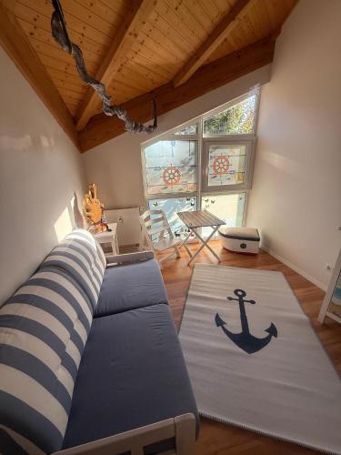 a living room with a couch and an anchor rug at Küstenloft-Leuchturm in Rostock