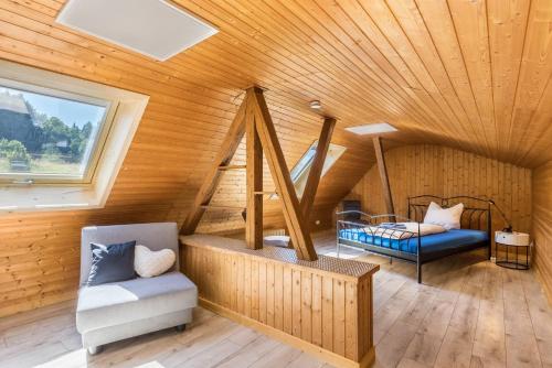 a room with a wooden ceiling with a bed and a chair at B463 Penthouse in Albstadt