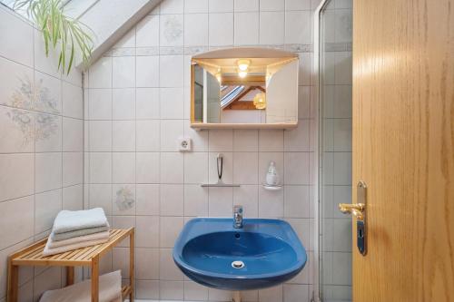 a bathroom with a blue sink and a mirror at Gästehaus Weingut Mangel in Endingen