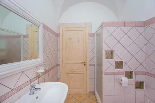 a bathroom with a sink and a toilet and a door at Villa Funtana Cortese in Orosei
