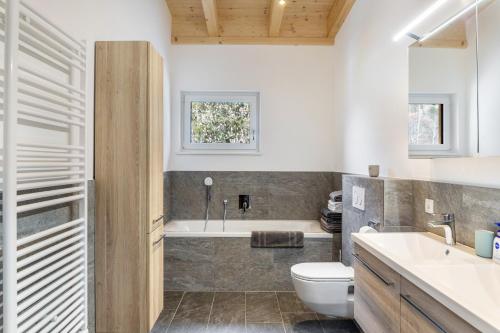 a bathroom with a tub and a toilet and a sink at Apartment Lorenz in Scharnitz