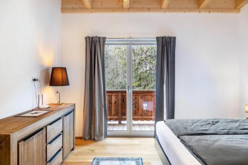a bedroom with a bed and a sliding glass door at Apartment Lorenz in Scharnitz