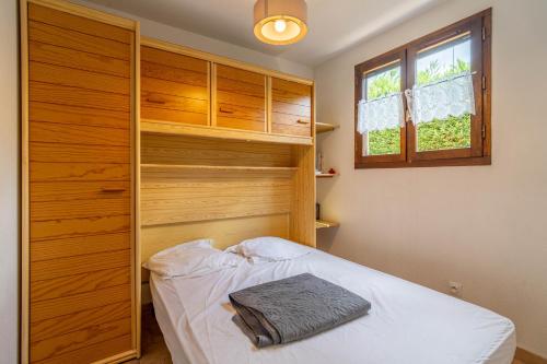 a bedroom with a bed and a wooden closet at Maison 6 Pers, proche de la plage in Vendres